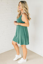Blonde woman wearing a knee length ribbed kit dress.