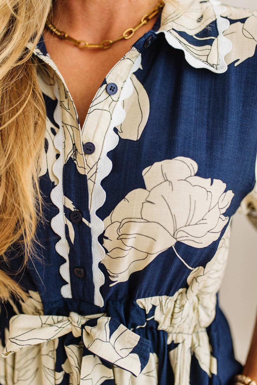 Navy blue dress with beige floral patterns worn by a person