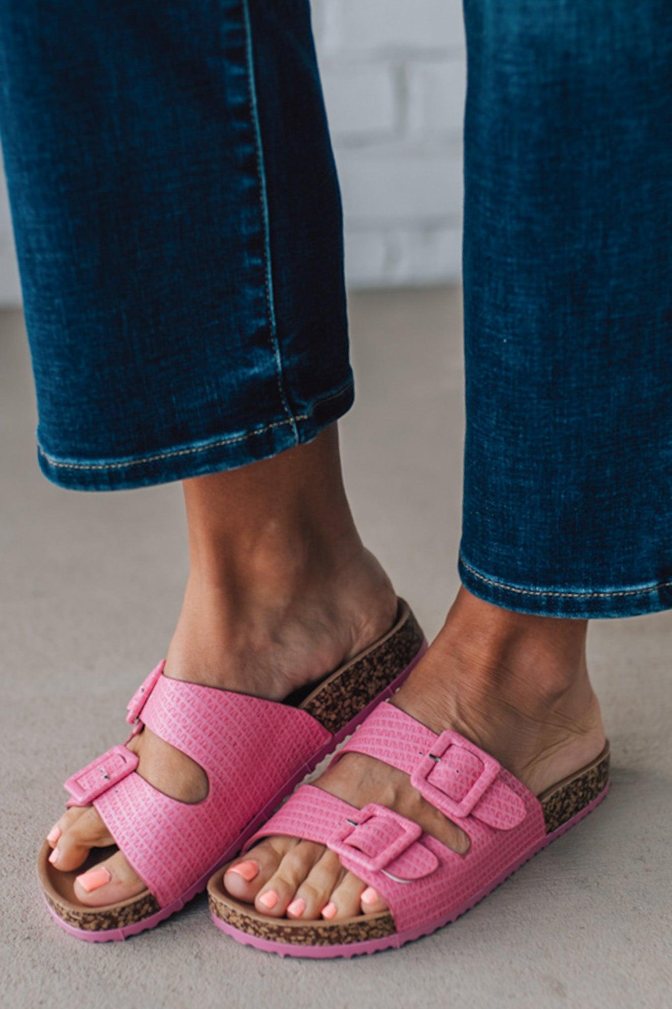 girl modeling a casual dark pink textured sandal with double straps and a cork bottom