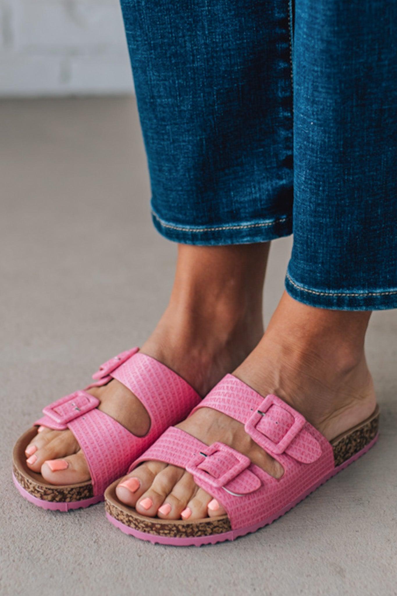 girl modeling a casual dark pink textured sandal with double straps and a cork bottom