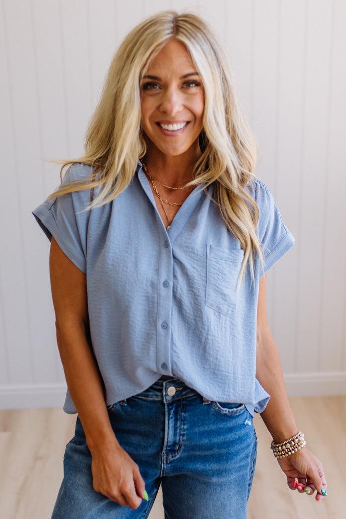 Woman wearing a light blue shirt and jeans indoors
