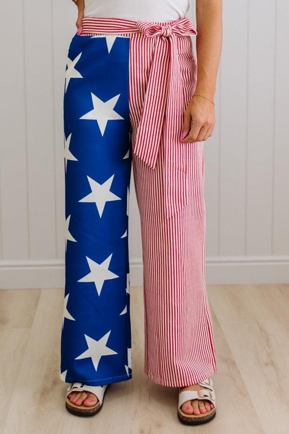 Person wearing a blue and white star-patterned pant leg, with another leg that is red and white striped.