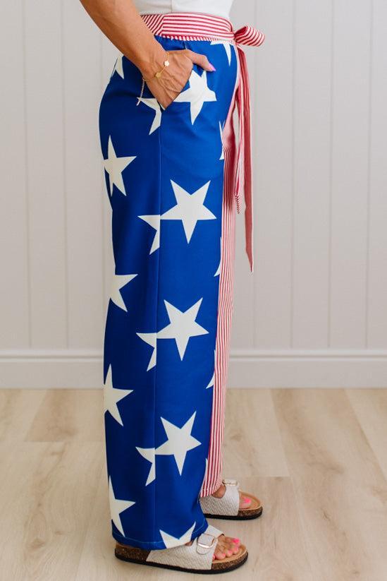 Person wearing a blue and white star-patterned pant leg, with another leg that is red and white striped.