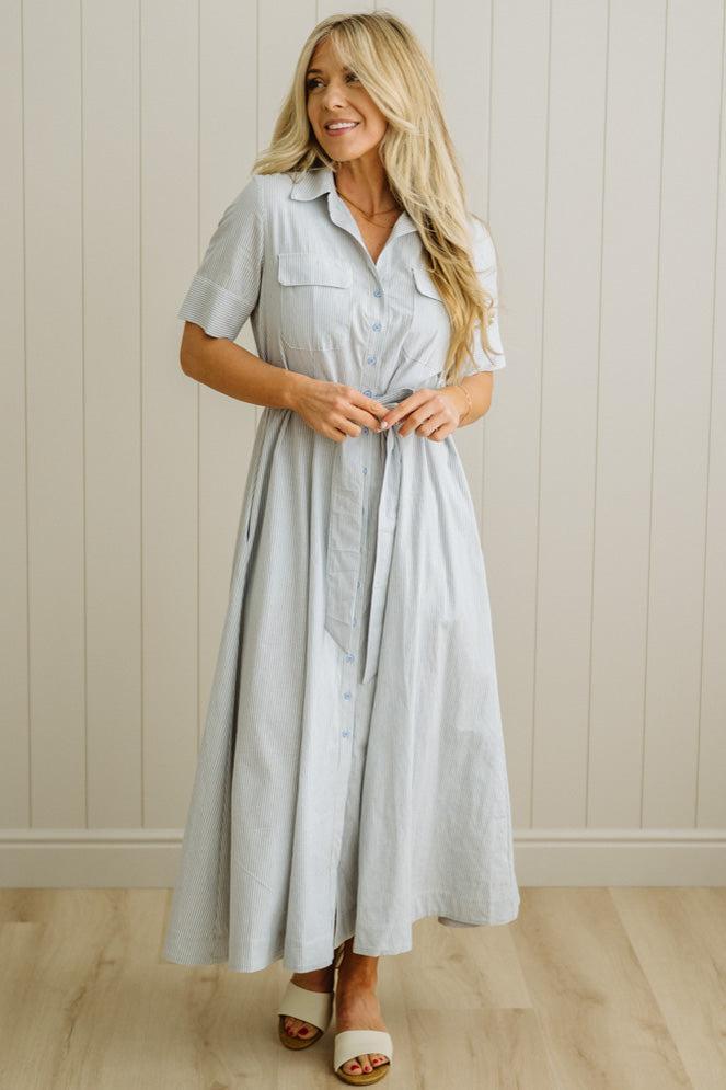 Blonde Woman Wearing a Striped Cotton Button Down Maxi Dress in Light Blue and White Fine Stripes