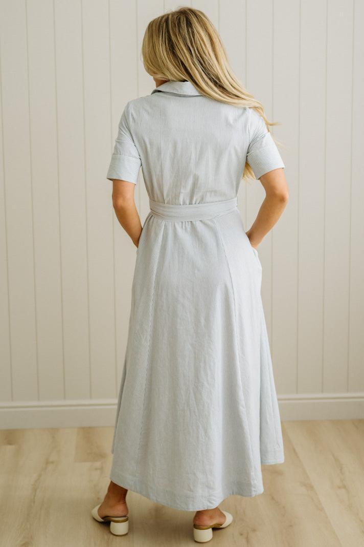 Blonde Woman Wearing a Striped Cotton Button Down Maxi Dress in Light Blue and White Fine Stripes