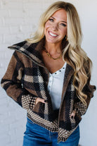 Woman wearing a plaid jacket with a white background