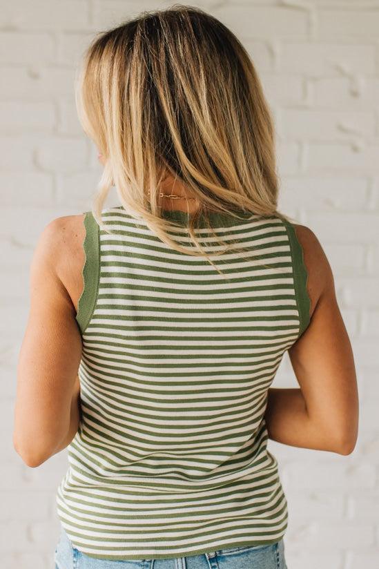 BLONDE WOMAN WEARING A CONTRAST COLOR SCALLOP FINISHED, CREW NECK, SLEEVELESS STRIPED SWEATER.