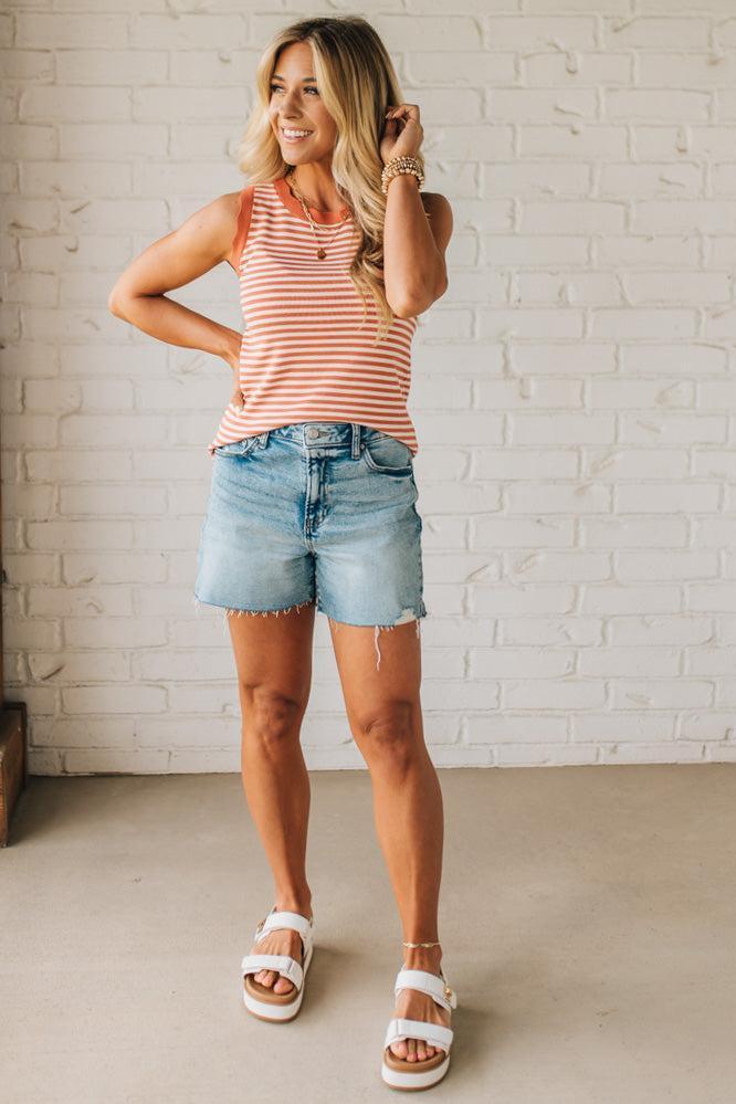 BLONDE WOMAN WEARING A CONTRAST COLOR SCALLOP FINISHED, CREW NECK, SLEEVELESS STRIPED SWEATER.
