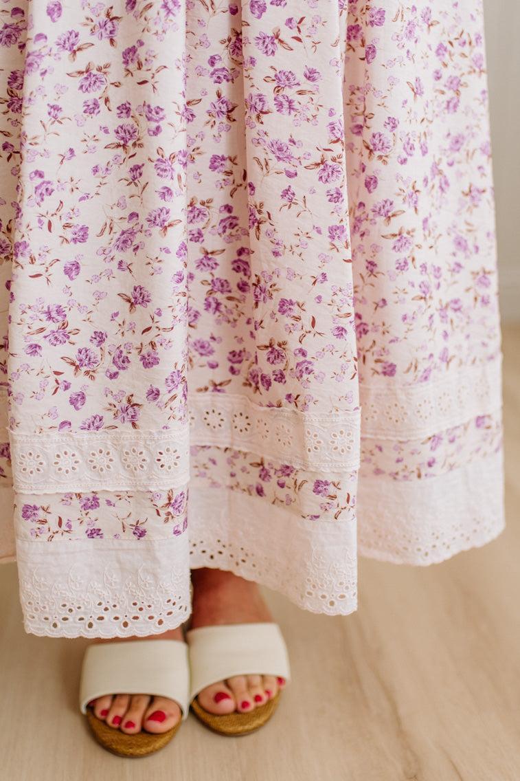Floral dress with purple flowers on a neutral background