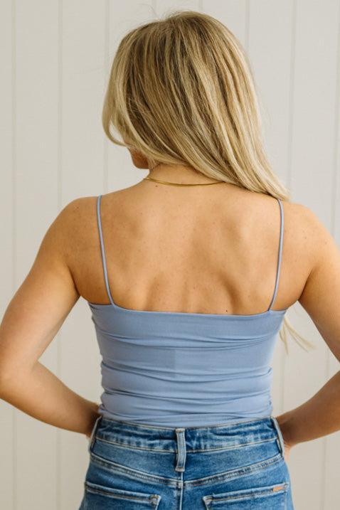 Blonde woman in jeans wearing a basic solid cami in blue.