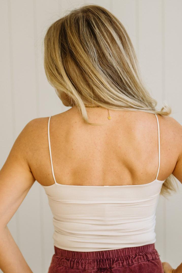 Blonde woman in jeans wearing a basic solid cami in ecru cream.