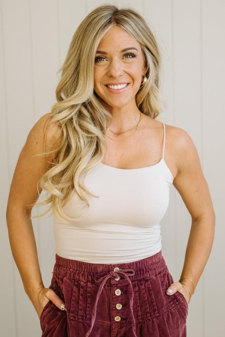 Blonde woman in jeans wearing a basic solid cami in ecru cream.