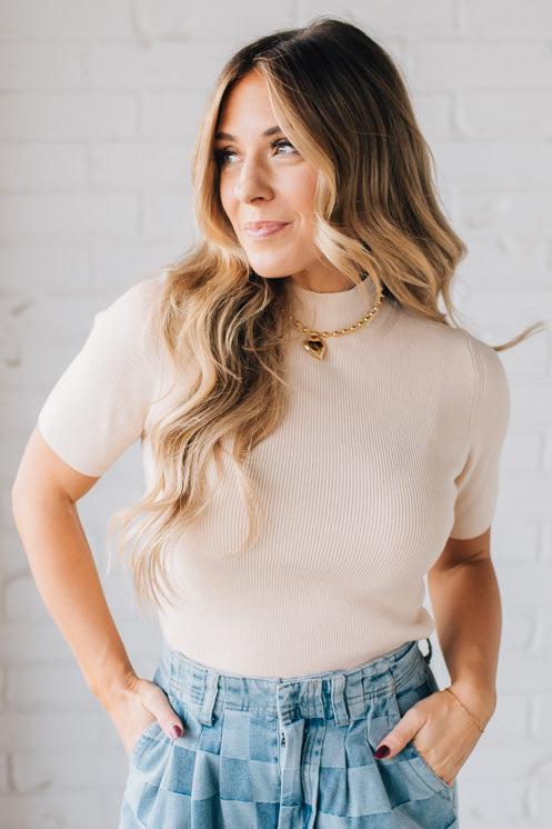 Blonde girl modeling a half sleeve mini ribbed fitted top with mock neck