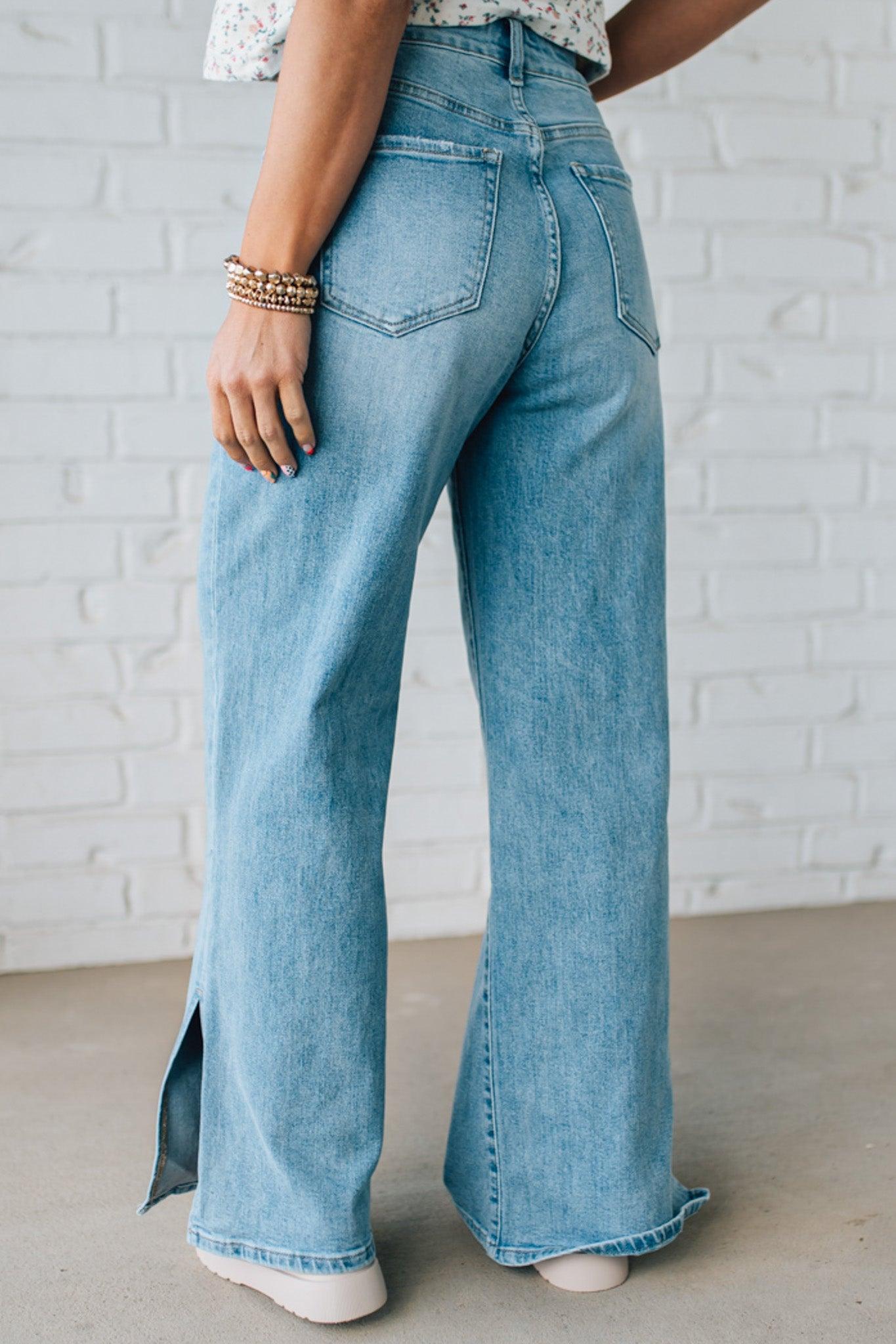 BLONDE WOMAN WEARING DRAWSTRING WAIST DETAIL STRETCH SIDE SLIT WIDE LEG JEAN IN MEDIUM BLUE.