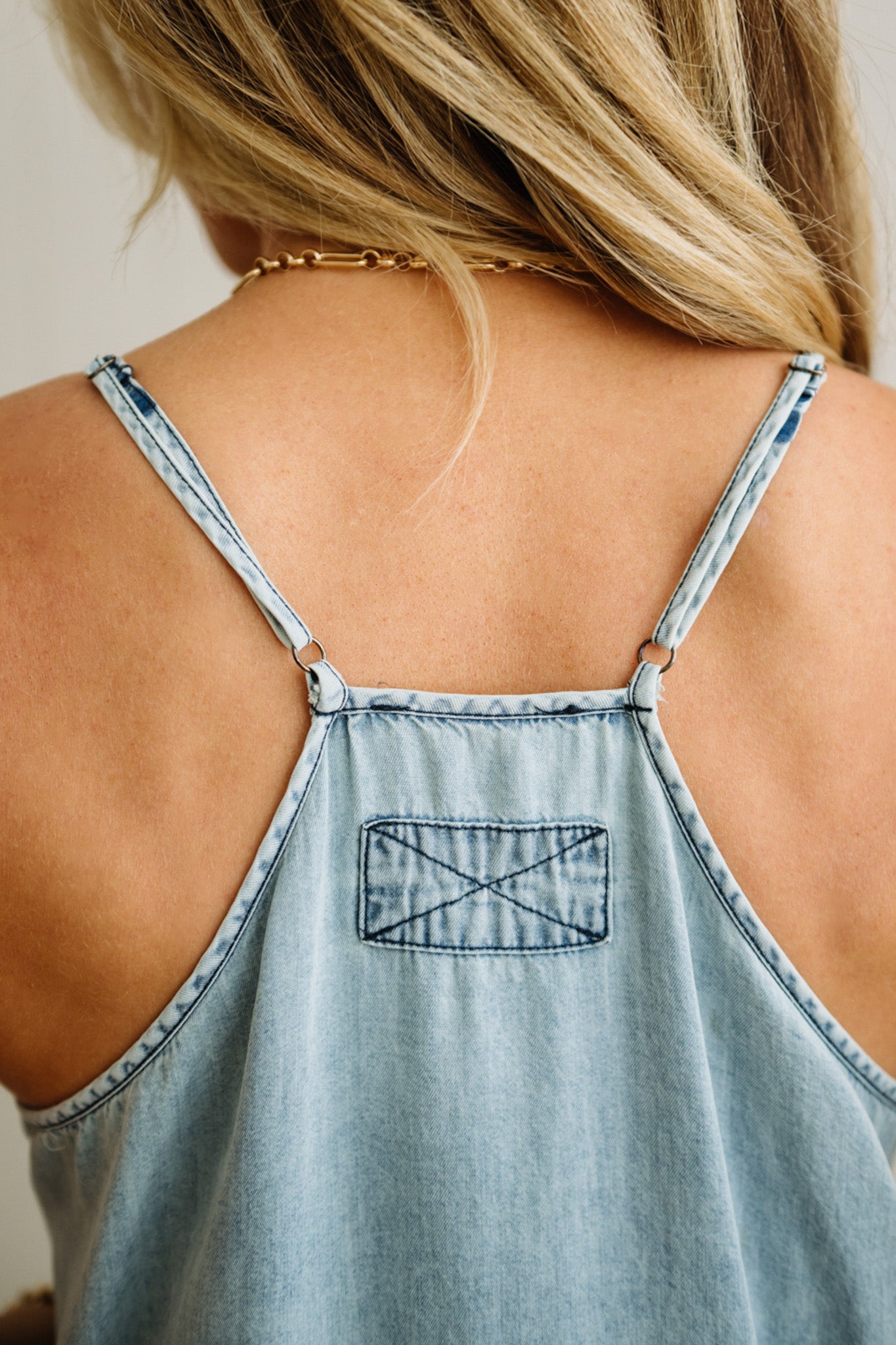 Light blue denim tank top with a back detail on a person.