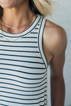 woman wearing a black and white striped tank dress that is knee length and has side pockets
