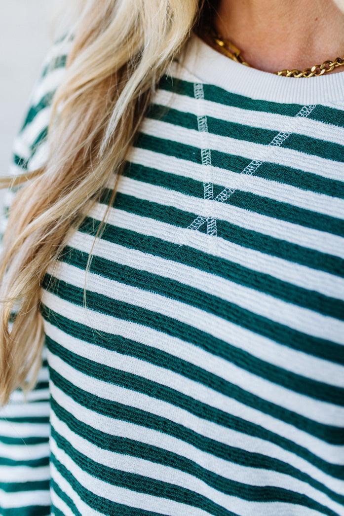 Close-up of a person wearing a green and white striped shirt.