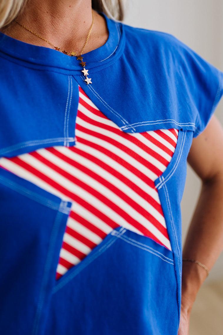 Blue shirt with a red and white star design on a neutral background
