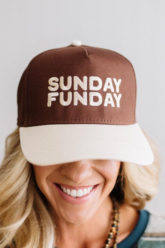Blonde woman in a plaid green top wearing a hat that is brown with a cream brim, and cream bold lettering embroidered saying: SUNDAY FUNDAY