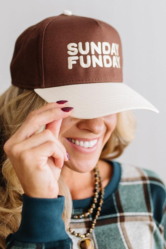 Blonde woman in a plaid green top wearing a hat that is brown with a cream brim, and cream bold lettering embroidered saying: SUNDAY FUNDAY
