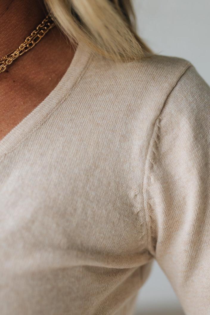 Close-up of a beige sweater with a blurred background