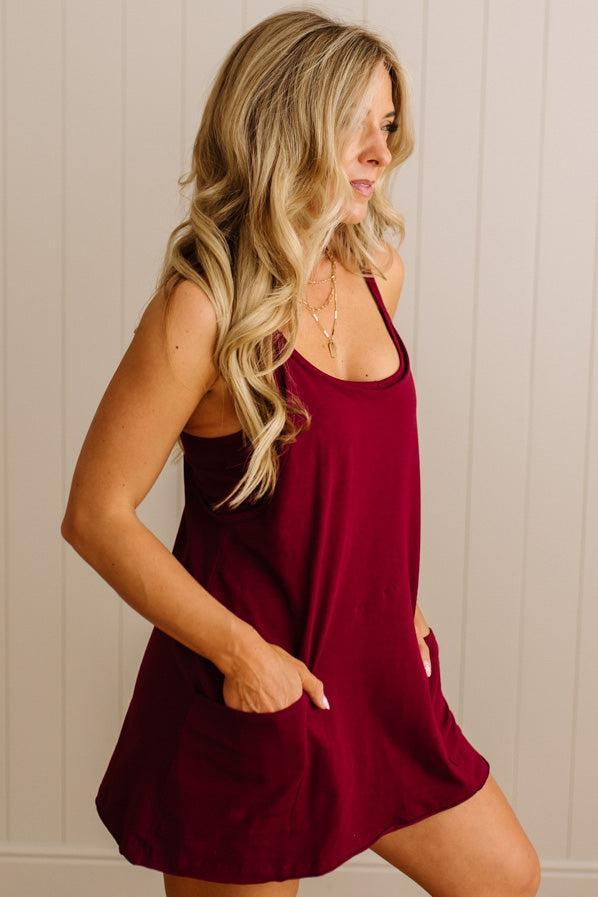 Woman wearing a burgundy dress against a neutral background
