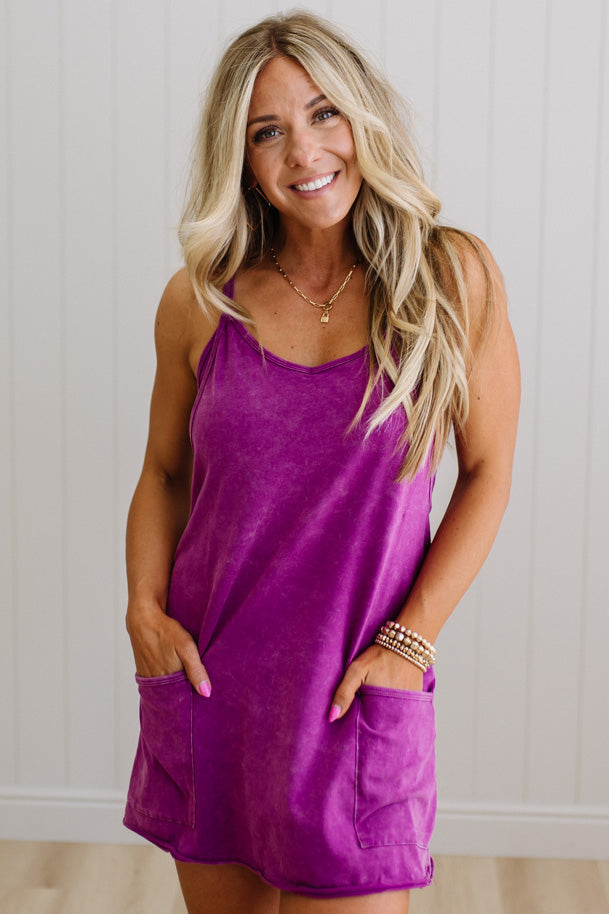 Woman wearing a purple dress with a neutral background