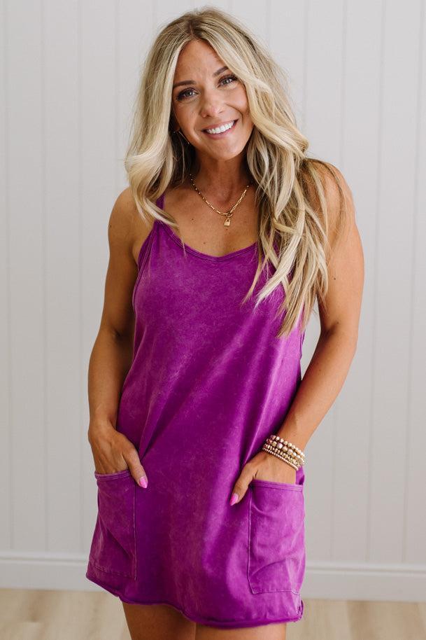 Woman wearing a purple dress with a neutral background