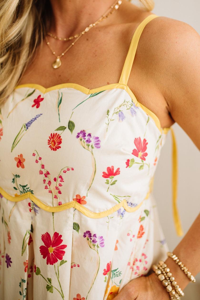 Floral dress with yellow trim worn by a person, with a neutral background