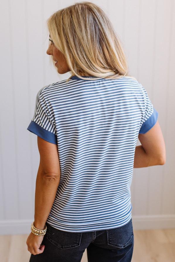 Woman wearing a blue and white striped shirt against a plain background