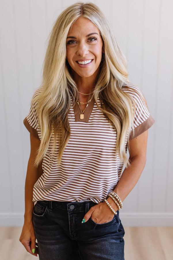 Woman wearing a striped shirt with a plain background