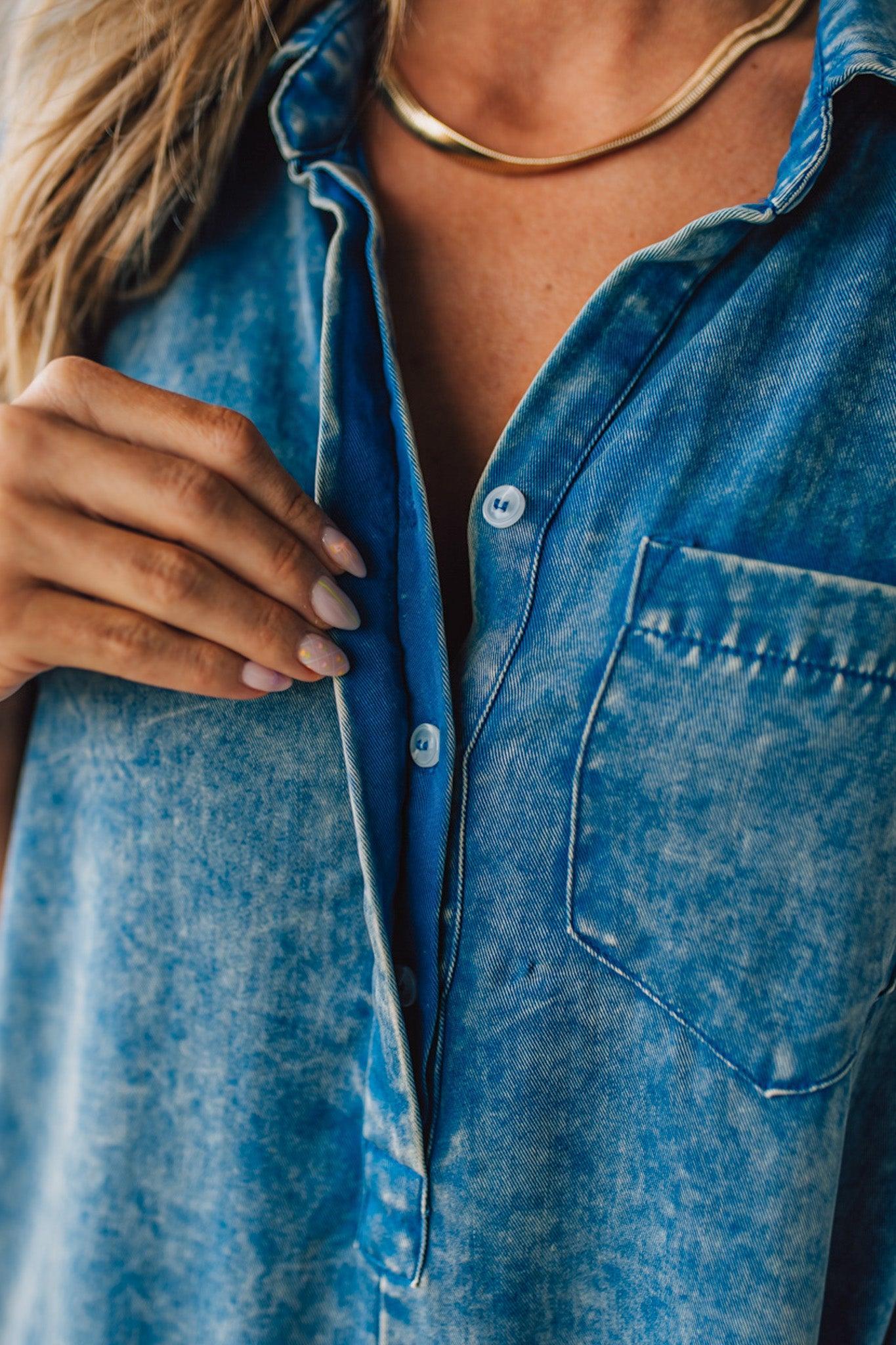 BLONDE WOMAN WEARING A TENCEL MINERAL WASHED HALF BUTTON SHIRTS ROMPER WITH POCKETS.