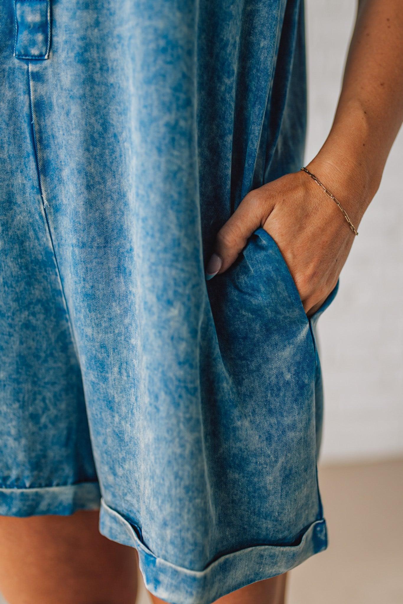 BLONDE WOMAN WEARING A TENCEL MINERAL WASHED HALF BUTTON SHIRTS ROMPER WITH POCKETS.