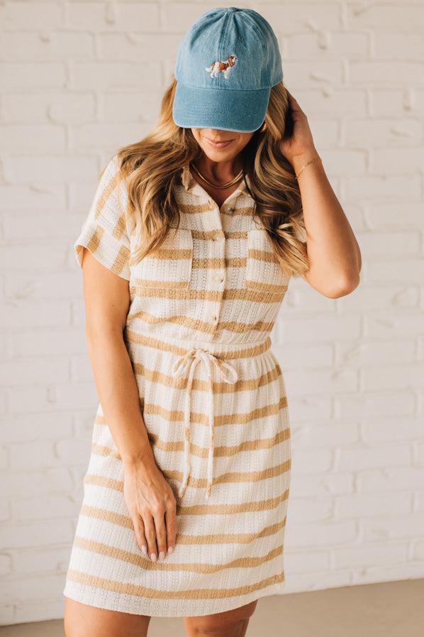 BLONDE WOMAN WEARING A TEXTURED BUTTON UP, STRETCH WAIS WAIST WITH DRAWSTRING, COLLARED MINI DRESS, WITH SIDE POCKETS.