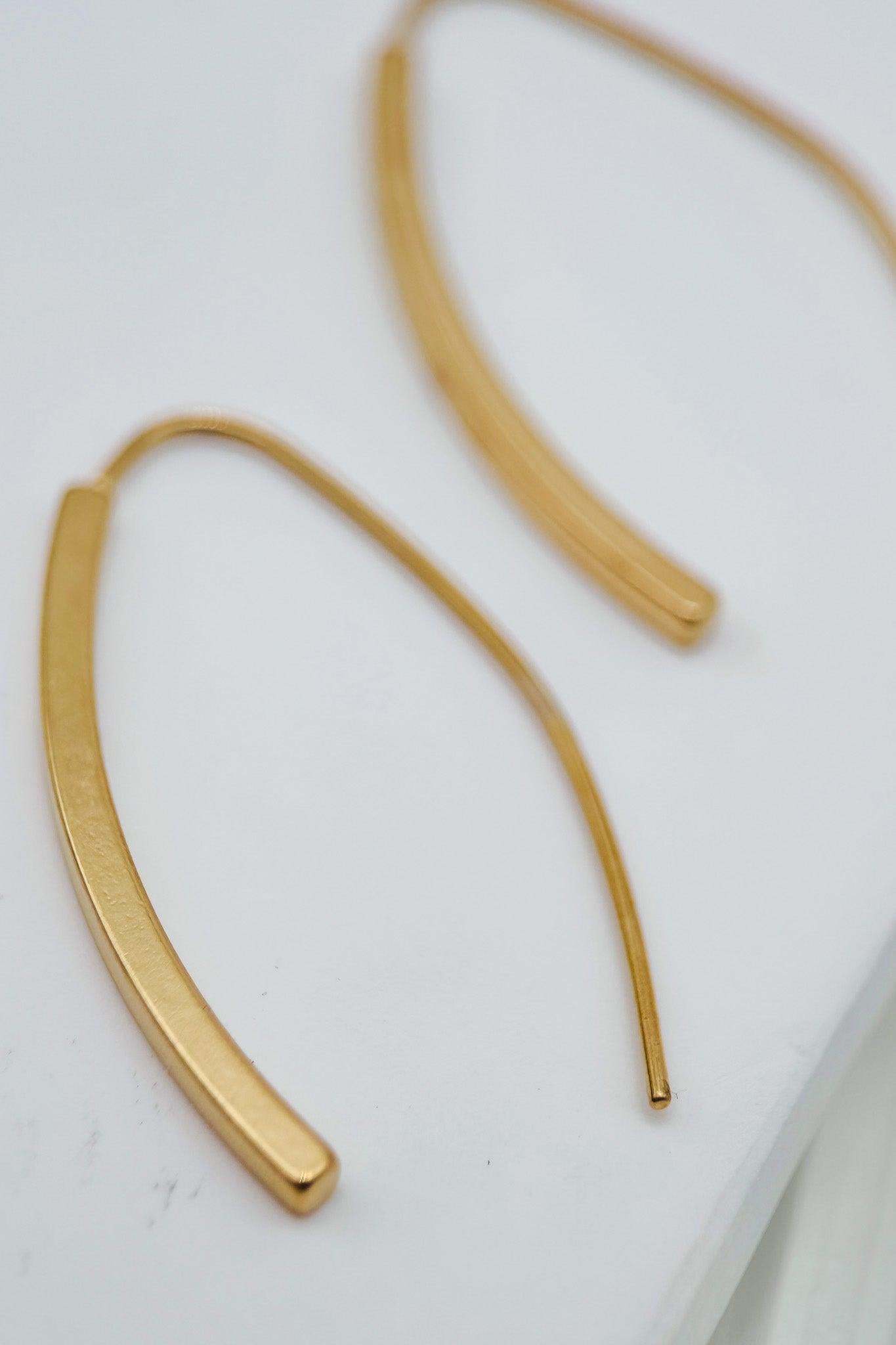 Gold hoop earrings on a white surface