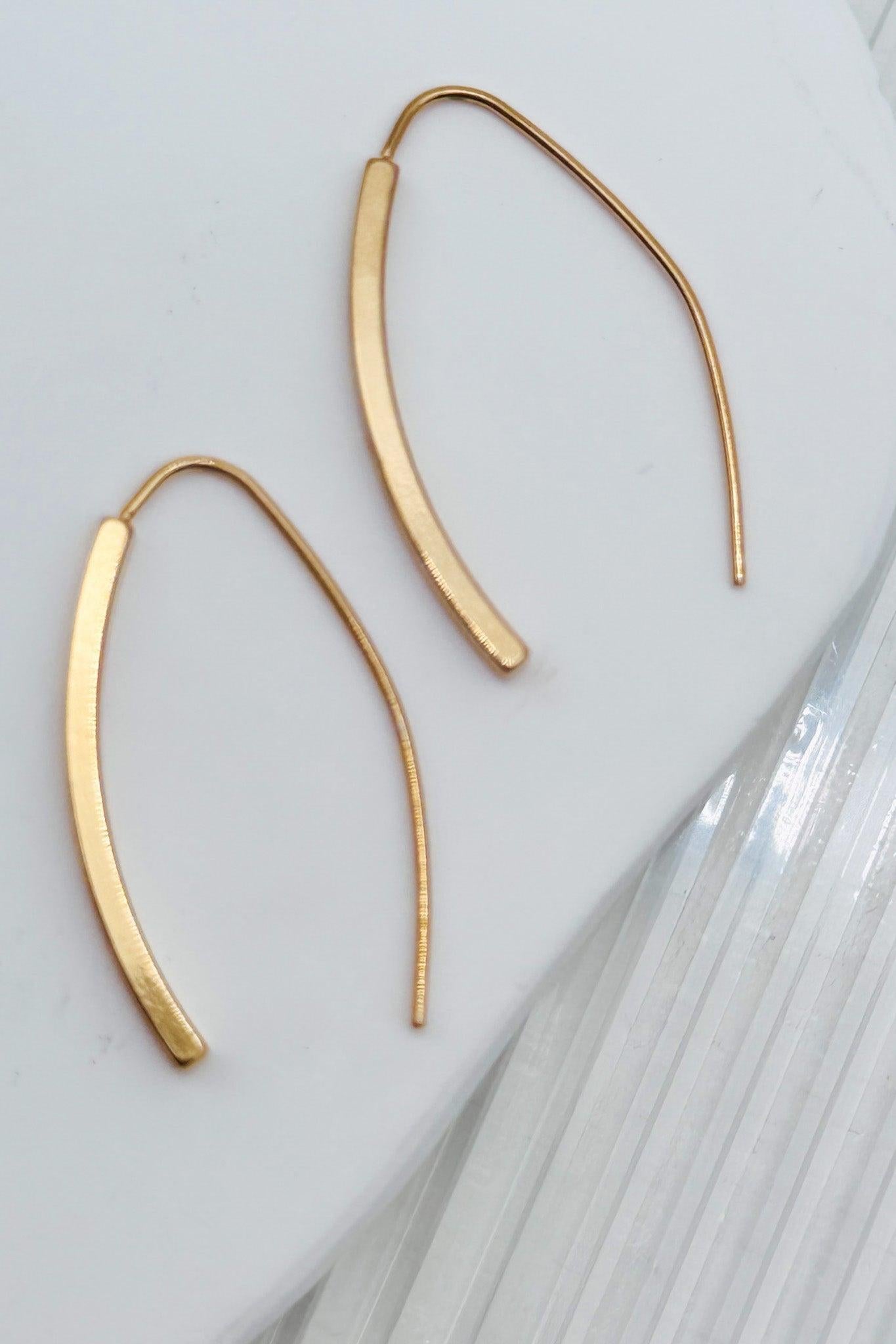 Gold hoop earrings on a light gray background