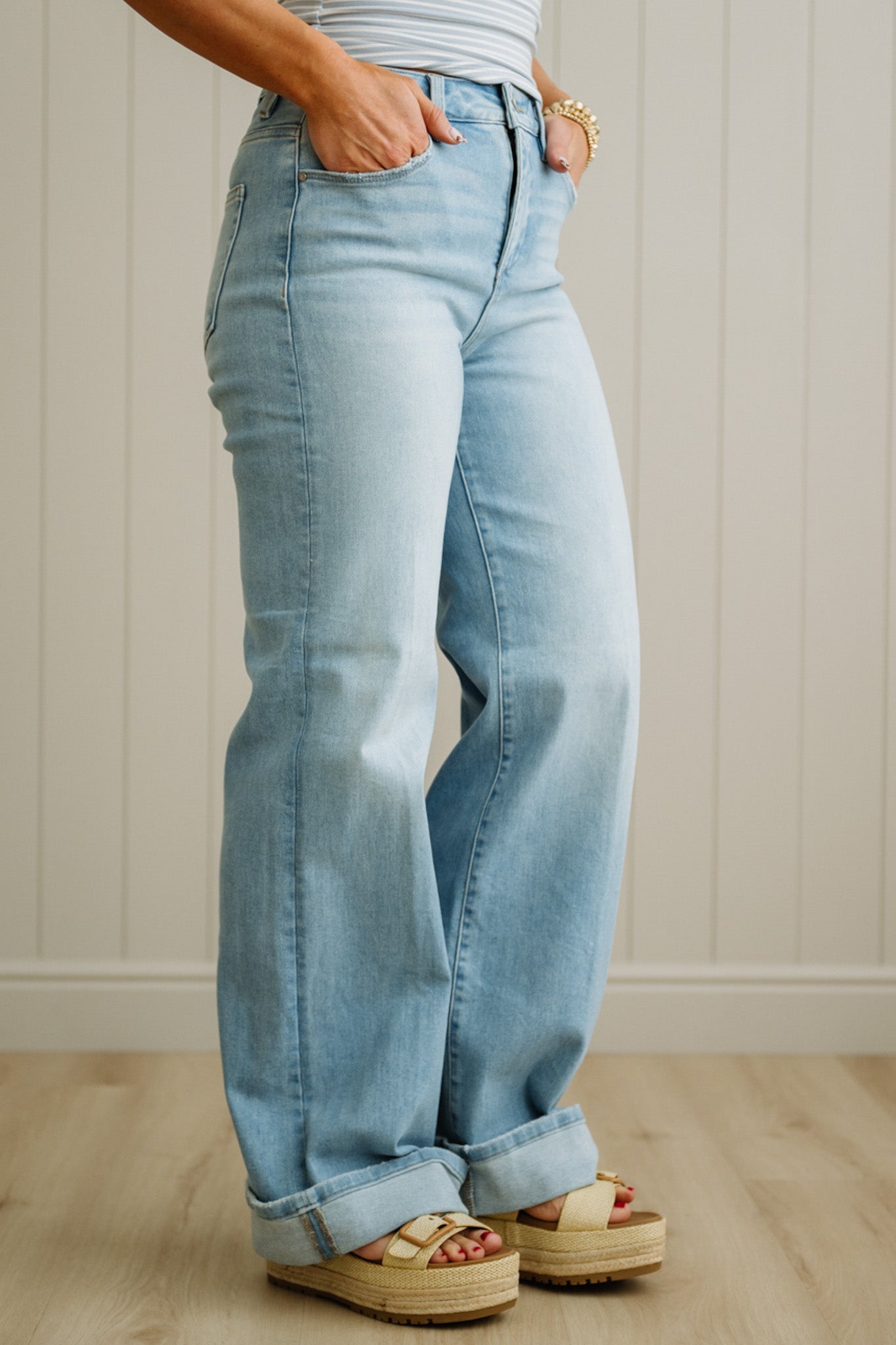 Person wearing light blue jeans with a neutral background