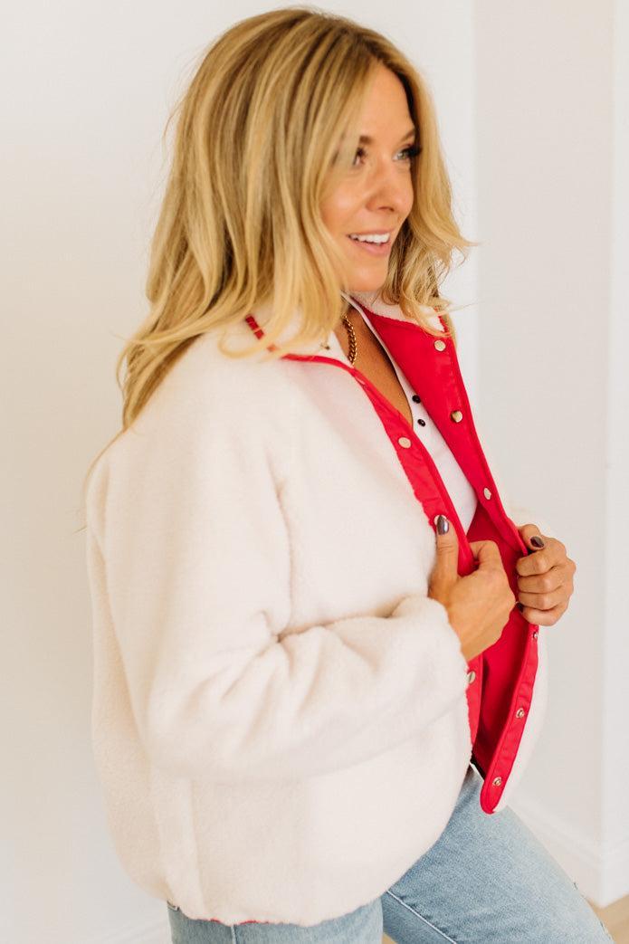 Woman wearing a red and white jacket with a plain background