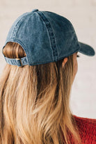 Blonde woman wearing a classic ball cap with USA embroidered at center front.