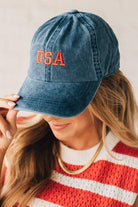 Blonde woman wearing a classic ball cap with USA embroidered at center front.