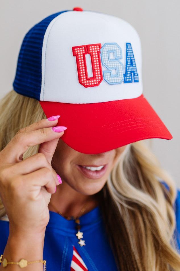 Person wearing a patriotic cap with 'USA' on a neutral background