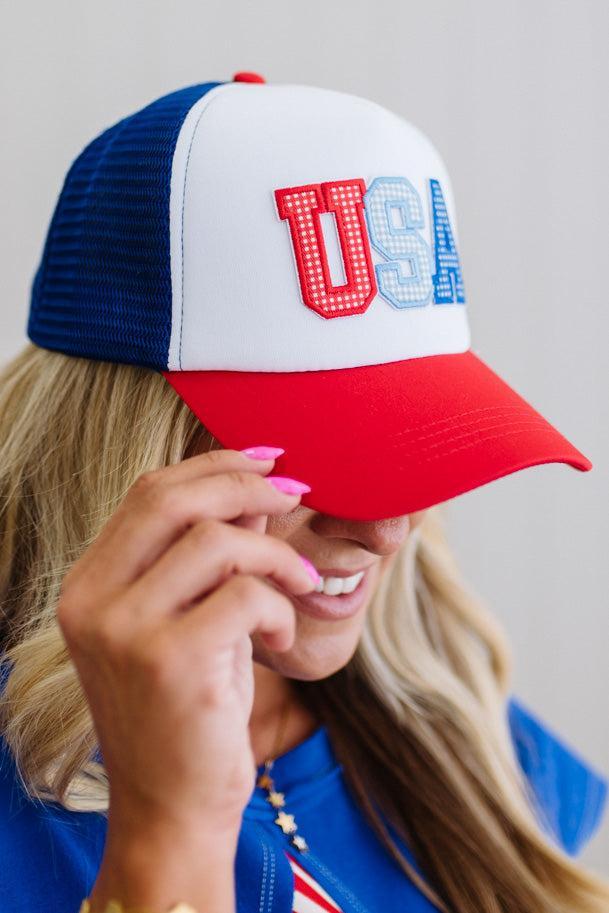 Person wearing a patriotic baseball cap with 'USA' on a plain background