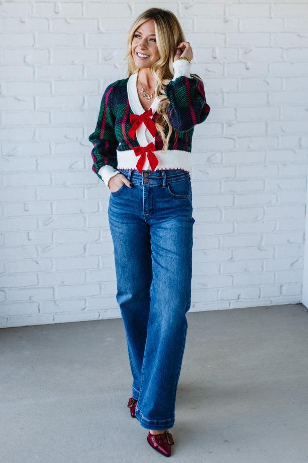 BLONDE WOMAN WEARING A VELVET BOW RIBBON EMBELLISHED CHRISTMAS CHECKER PLAID BUTTONED SWEATER CROP CARDIGAN