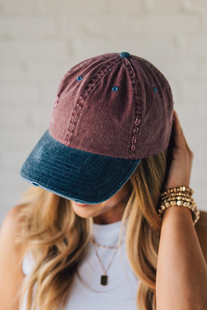 Blonde Woman Wearing a Burgundy and Navy Two-Toned Distressed Vintage Baseball Dad Hat.