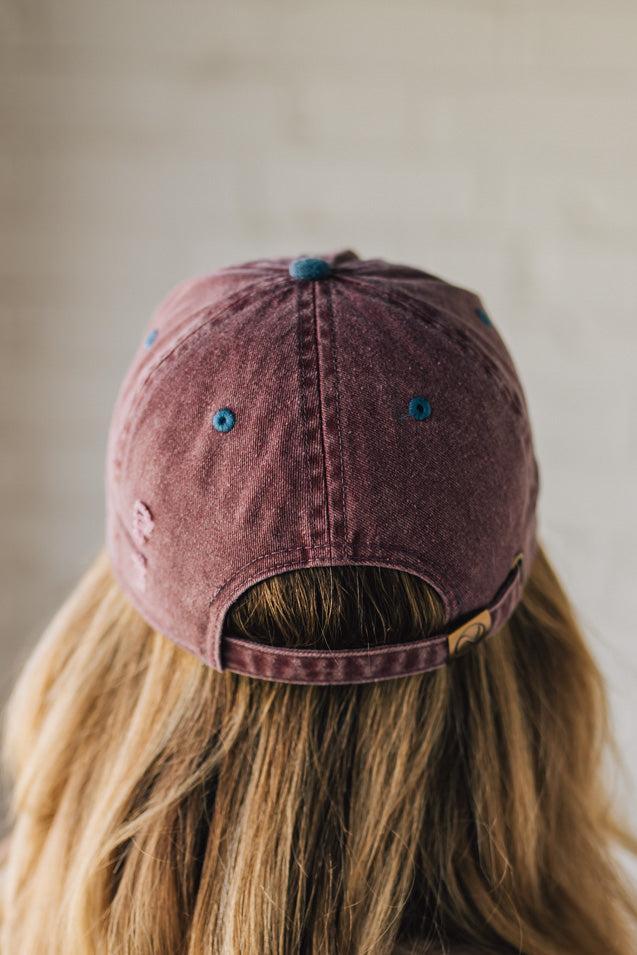 Blonde Woman Wearing a Burgundy and Navy Two-Toned Distressed Vintage Baseball Dad Hat.
