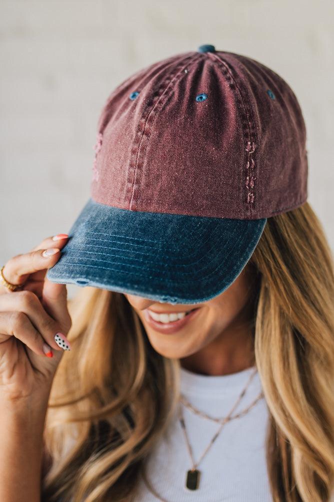 Blonde Woman Wearing a Burgundy and Navy Two-Toned Distressed Vintage Baseball Dad Hat.