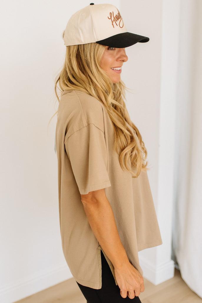 Woman wearing a beige cap and shirt against a white background