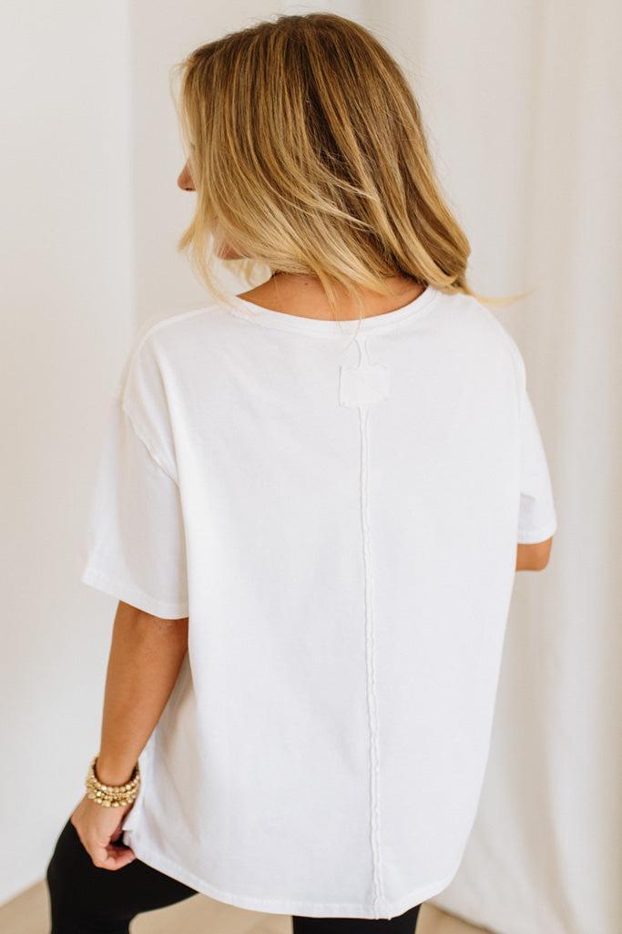 Person wearing a white t-shirt against a plain background