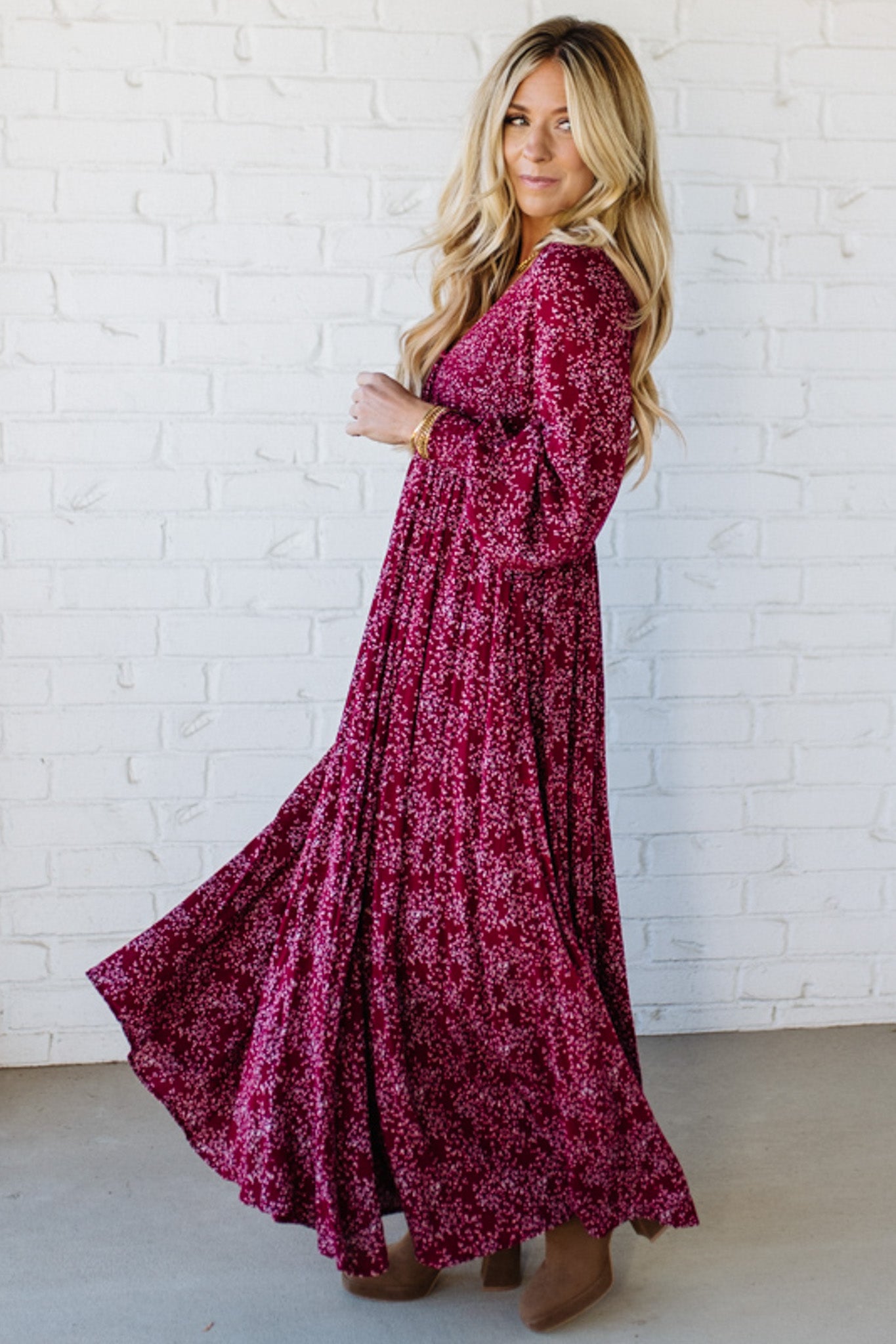 Blonde Woman Wearing a Smocked Floral Maxi Dress with Button Front and v-neckline in a deep wine red color.