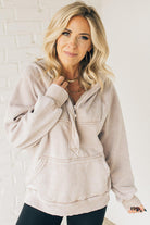 BLONDE WOMAN WEARING A SOLID COLOR ACID WASH FLEECE OVERSIZED 1/4 ZIP KANGAROO POCKET HOODIE.